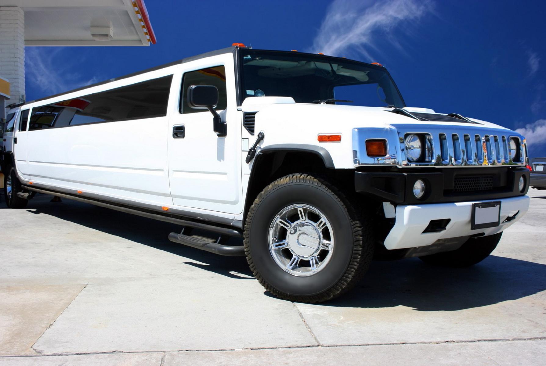 Weiße Hummer Limousine vor blauem Himmel